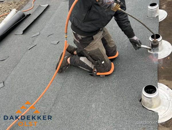 Dakdekker repareert bitumen dakleer bij dakdoorvoer in Olst