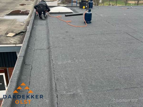 Dakdekker repareert bitumen dakbedekking op groot plat dak in Olst Dakdekker repareert bitumen dakbedekking op groot plat dak in Olst