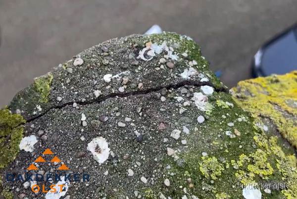 Beschadigde en verweerde nokvorst met scheuren en mos in Olst Beschadigde en verweerde nokvorst met scheuren en mos in Olst