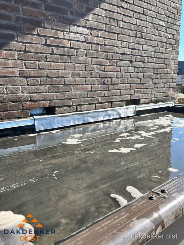 Stilstaand water op plat dak door slechte afwatering in Olst