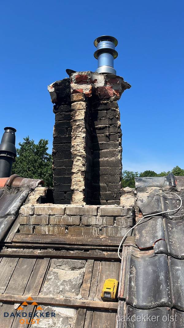 Beschadigde schoorsteen met nieuwe rookgasafvoer op oud dak in Olst