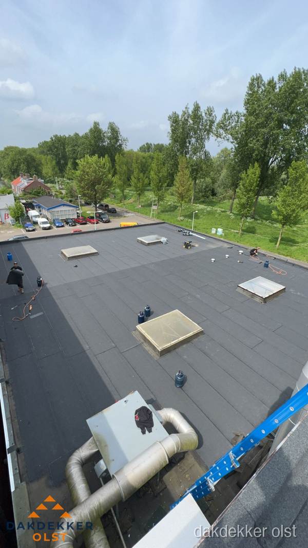 Dakdekker aan het werk op groot plat dak met bitumen in Olst Dakdekker aan het werk op groot plat dak met bitumen in Olst