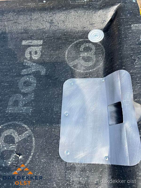 Dakdoorvoer met metalen afvoerplaat op bitumen dak in Olst